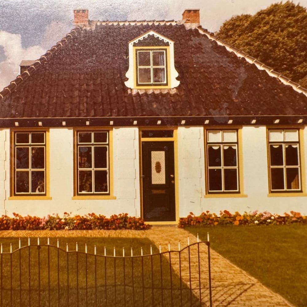 Wit monumentaal woonhuis met roedeverdeling, luiken en een sierlijke dakkapel, op een oudere kleurenopname